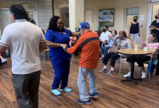 residents and staff dancing at Aravilla Clearwater Memory Care Community