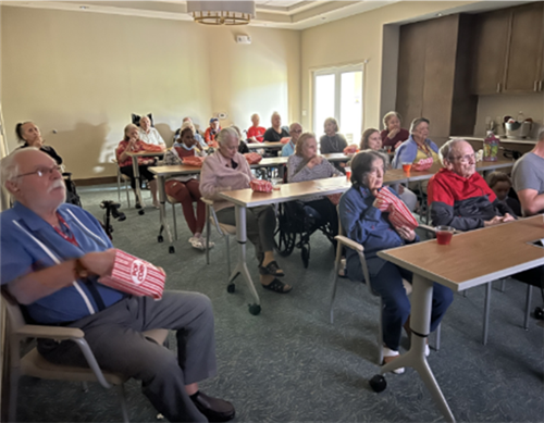 memory care activity senior residents watching a movie together