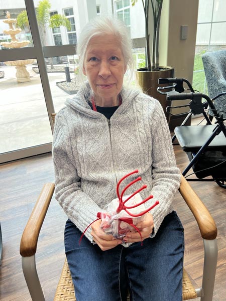 memory care resident Mary with her cornhole prize