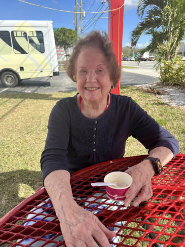 memory care resident sitting outdoors enjoying ice cream