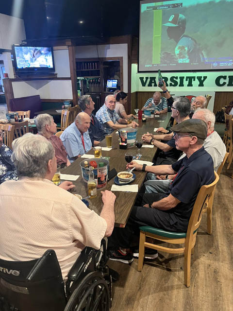 varsity club men sitting around a large table 