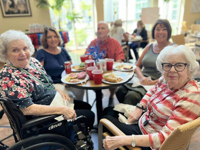 memory care residents sitting around tables celebrating