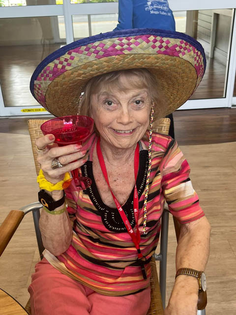 memory care resident ready for Cinco de Mayo - holding a drink and wearing a sombrero
