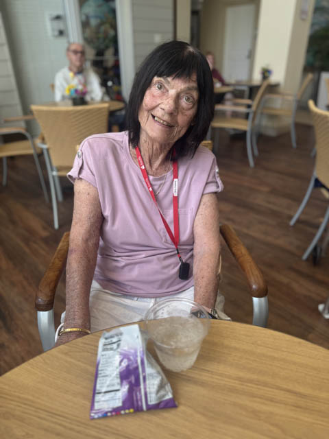 memory care resident spotlight memory care resident sitting at a table smiling